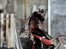 Vetreria Artistica Colleoni: a vibrant Murano glass horse sculpture on an active factory floor.