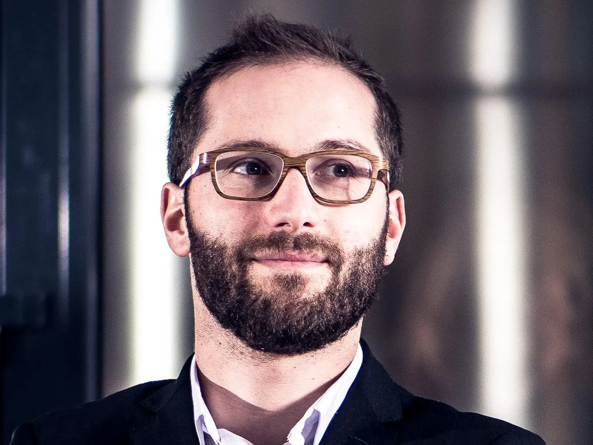Émilien Boutillat, cellar master, stands confidently in a winery, reflecting his hands-on winemaking background.