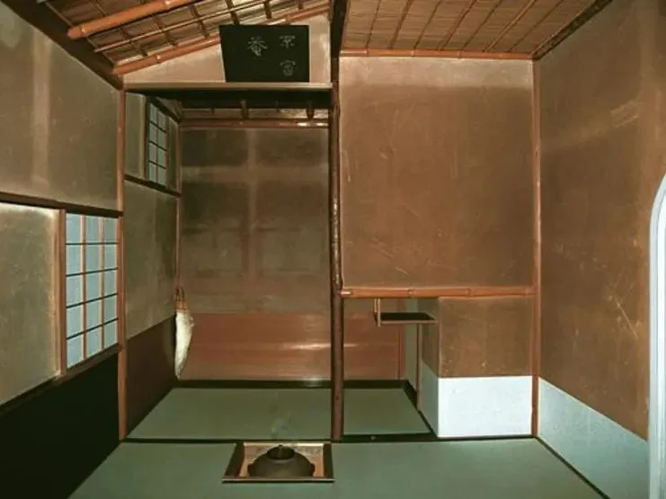 Interior of Fushin'an, a traditional Japanese tea house room with tatami flooring, shoji windows, earthen walls, bamboo ceiling, and a sunken hearth.