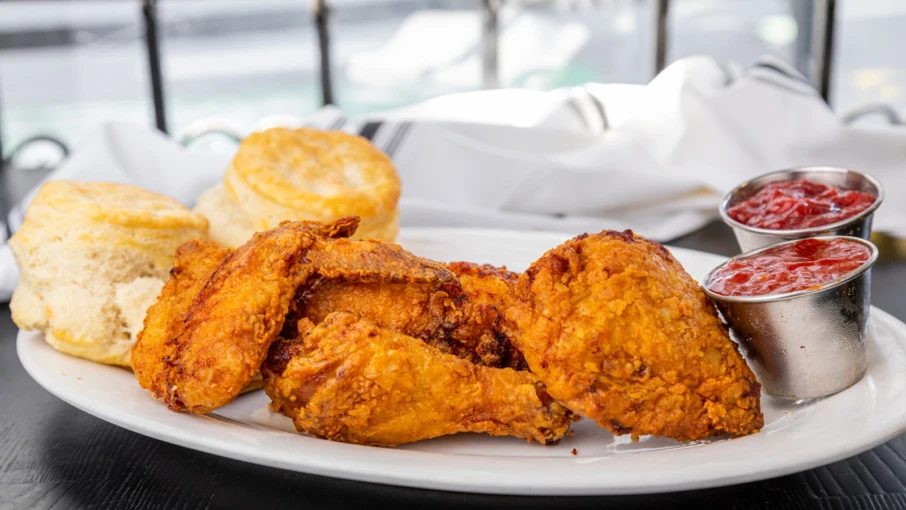 A plate of fried chicken with biscuits and dipping sauces, published on Resy's editorial page celebrating Mister Jiu's 10th anniversary; the source pa