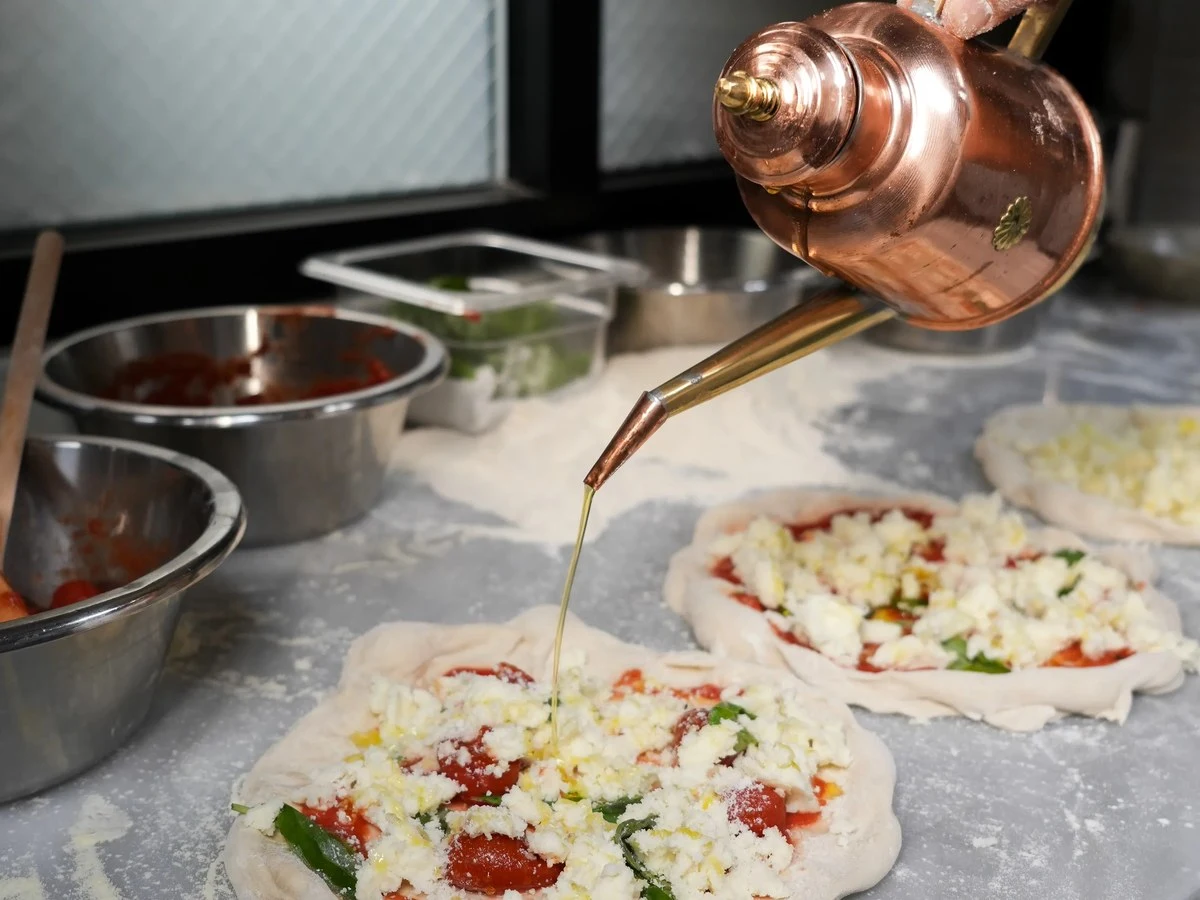 Pizza Studio Tamaki prepares a Tokyo-style Neapolitan pizza with a drizzle of olive oil.