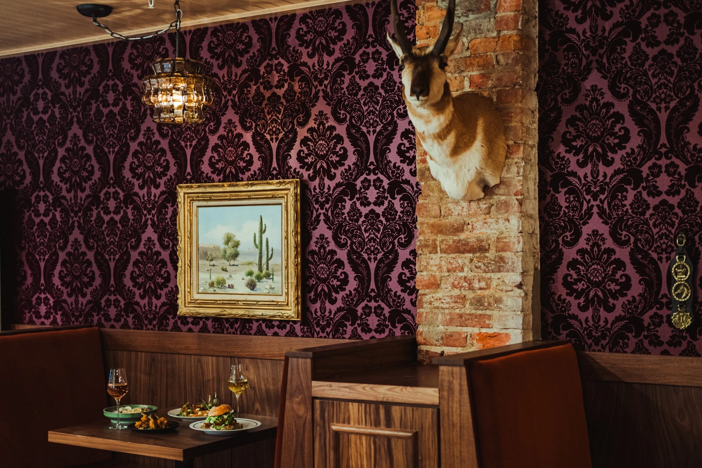 Kiyomi DC offers an eclectic dining experience with purple damask wallpaper and a mounted antelope.