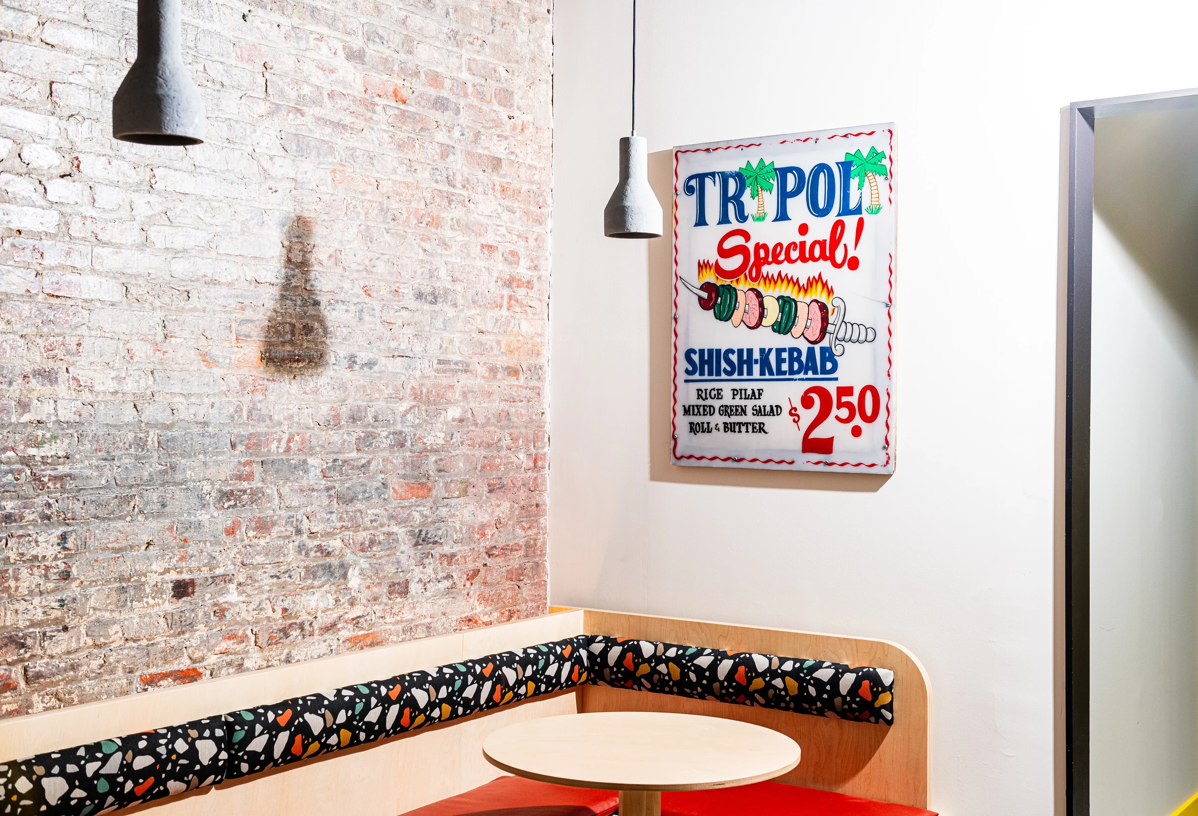 Yellow cafe features a vintage "TRIPOLI Special!" shish-kebab sign, a nod to chef Michael Rafidi's family history.