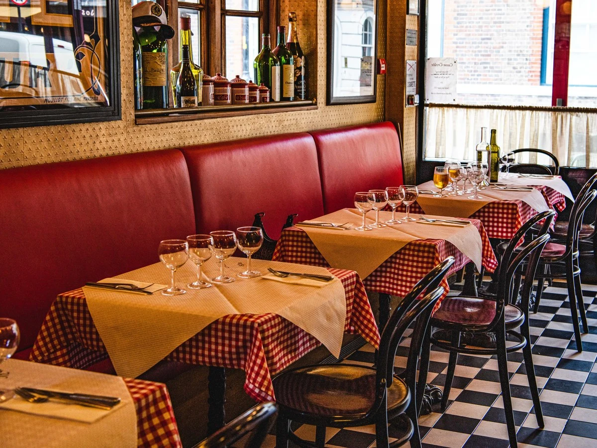 MOUILLOT FILS AINE MARSEILLE is visible in this classic French bistro, with red banquettes and checkered floors.