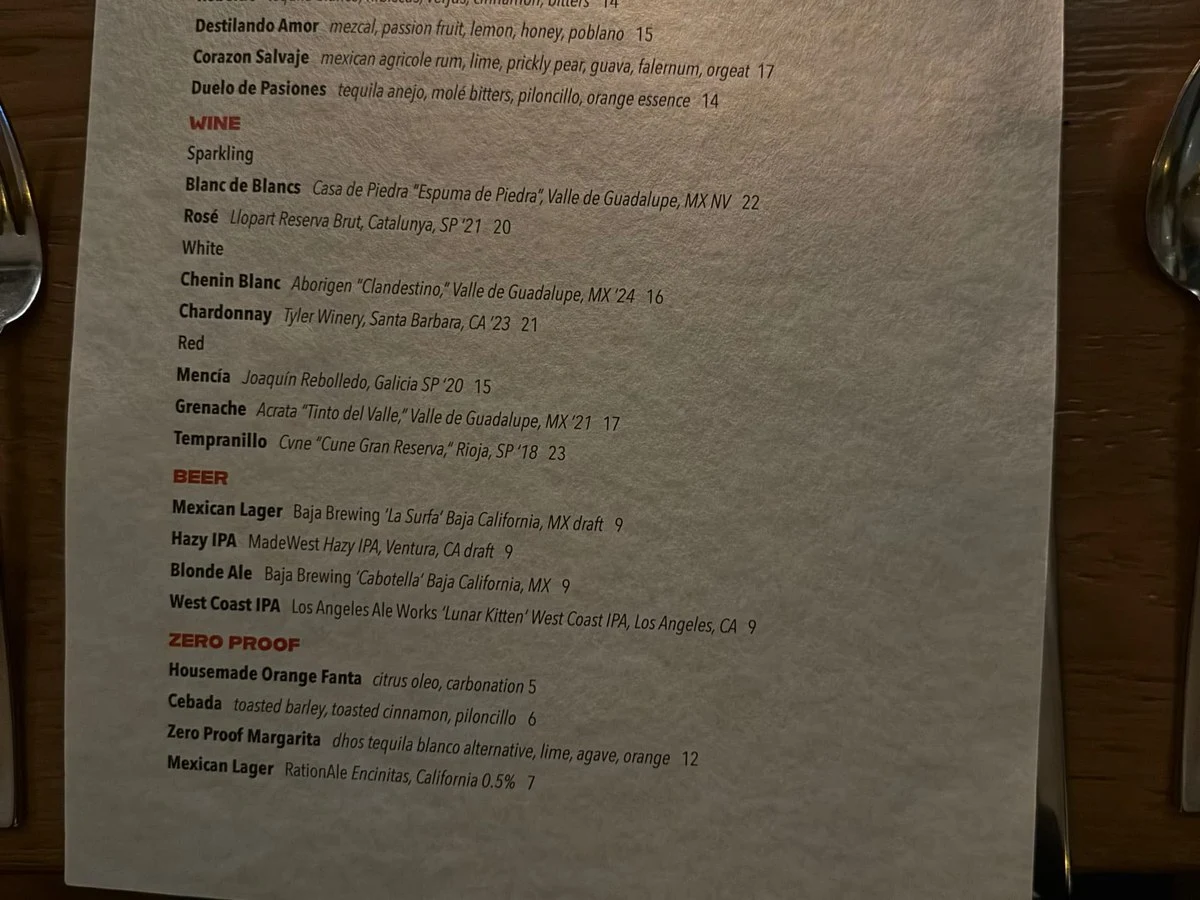 A menu from Broken Spanish Comedor displays a selection of wines, beers, and zero-proof drinks, with prices listed.