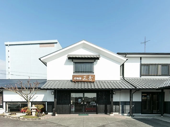 Exterior facade of Cutler Sansyu / Seki Hamono Museum, a traditional Japanese-style white-walled building with a dark tiled roof and wooden signage.