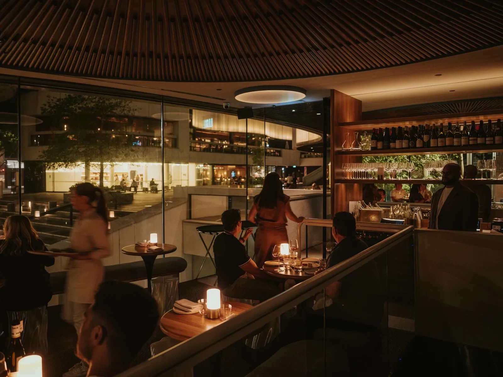 Aalia Wine Room interior with tables, wine bottles, and patrons enjoying the space.