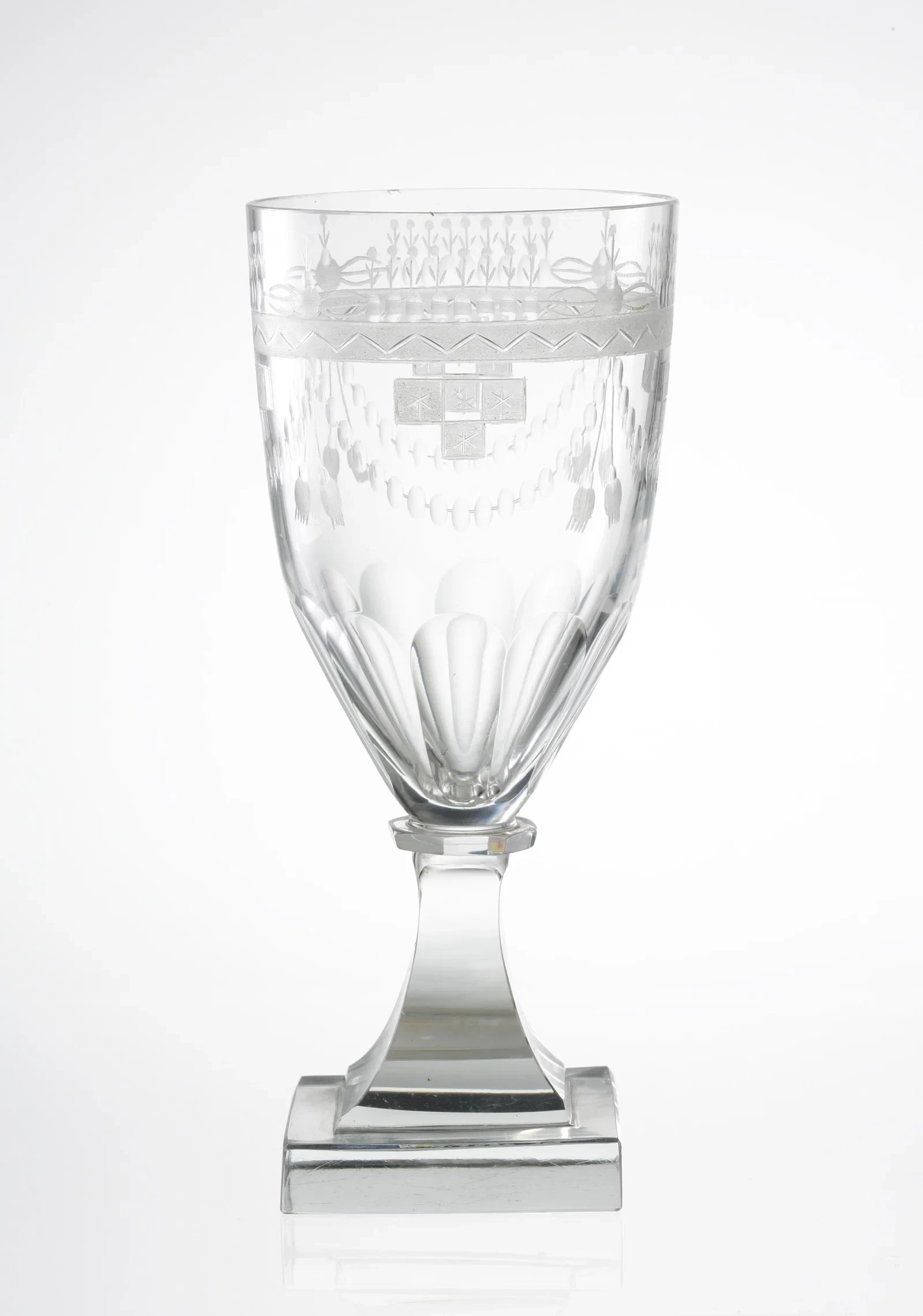 An engraved Orrefors red wine glass on a square foot, produced in 1915