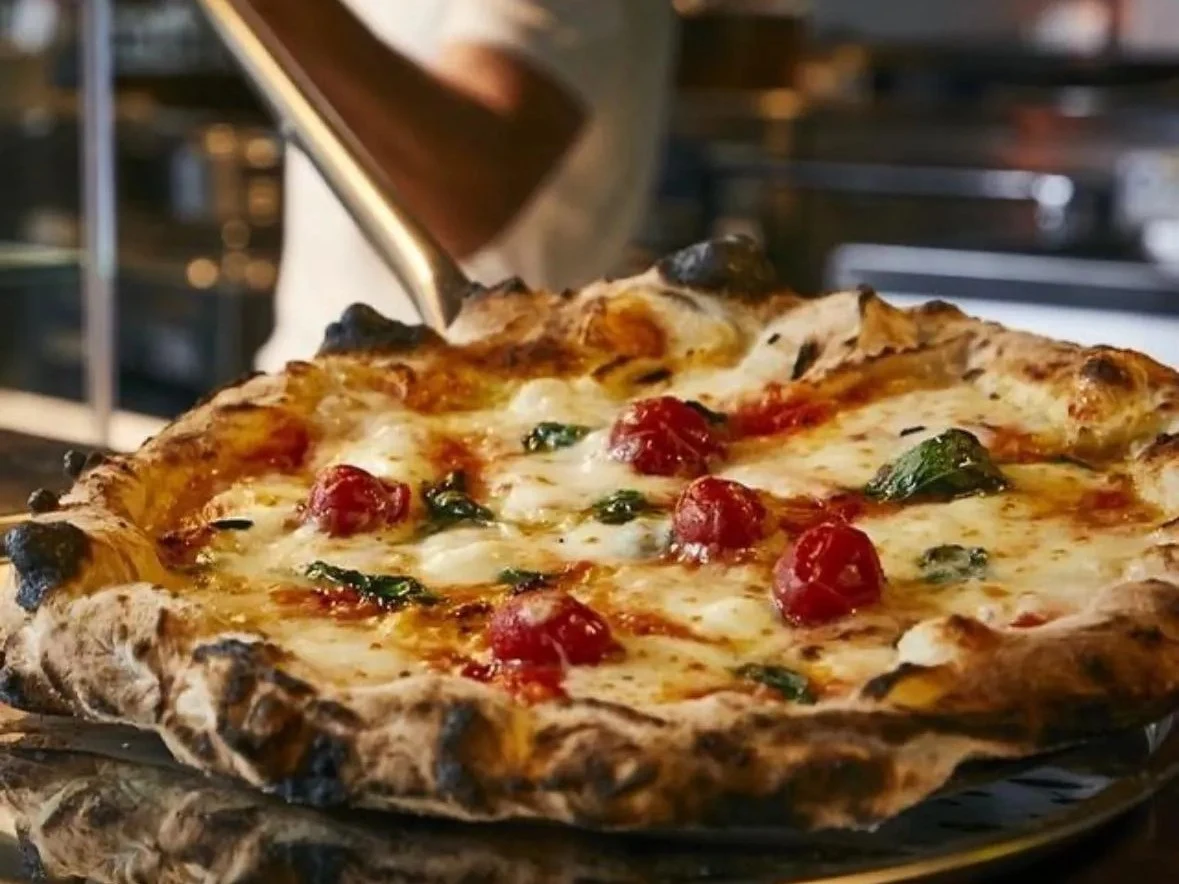 Pizza Studio Tamaki's Neapolitan-style pizza with mozzarella, cherry tomatoes, basil, and egg.