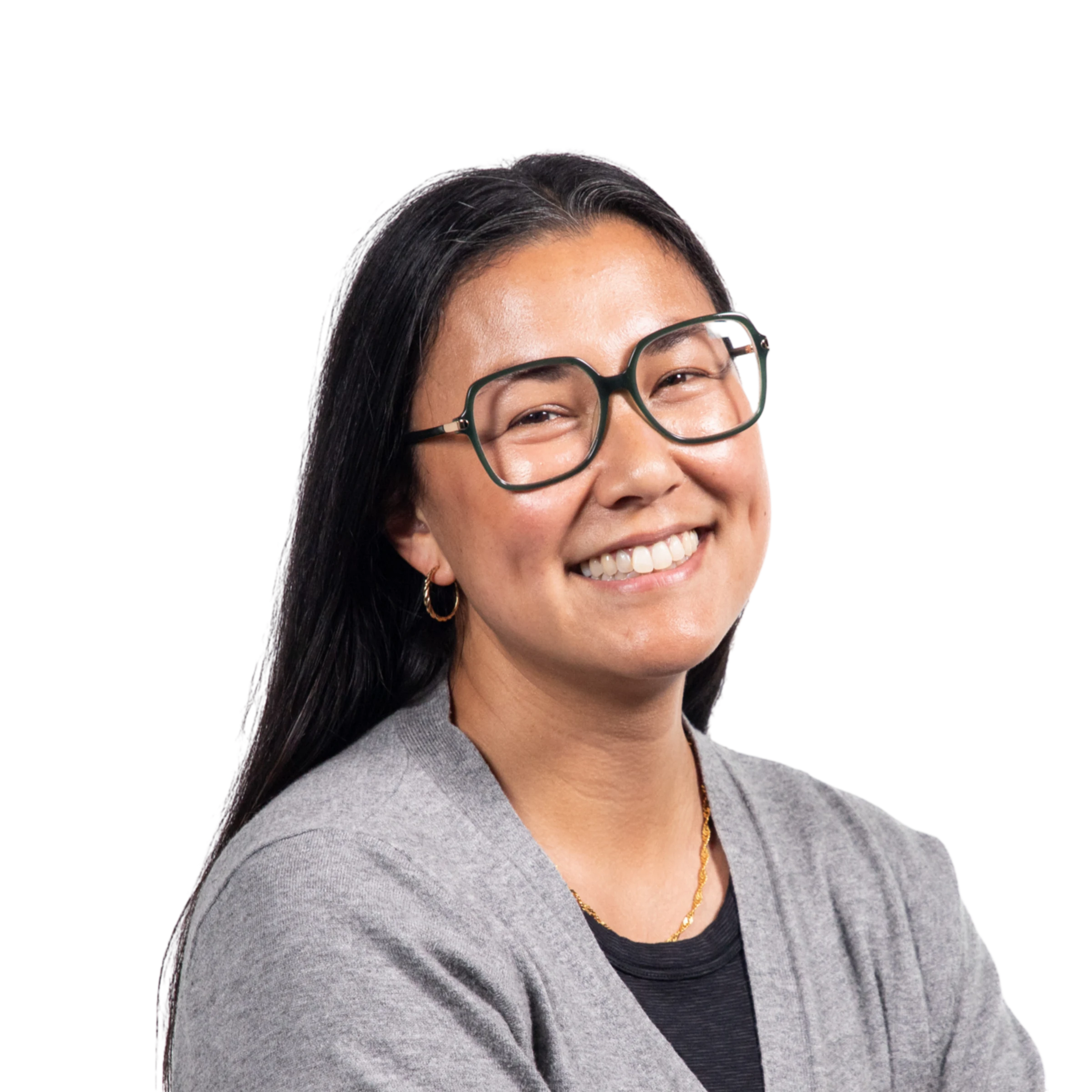 Professional portrait of a woman with long dark hair, glasses, gray cardigan, and gold jewelry against a black background
