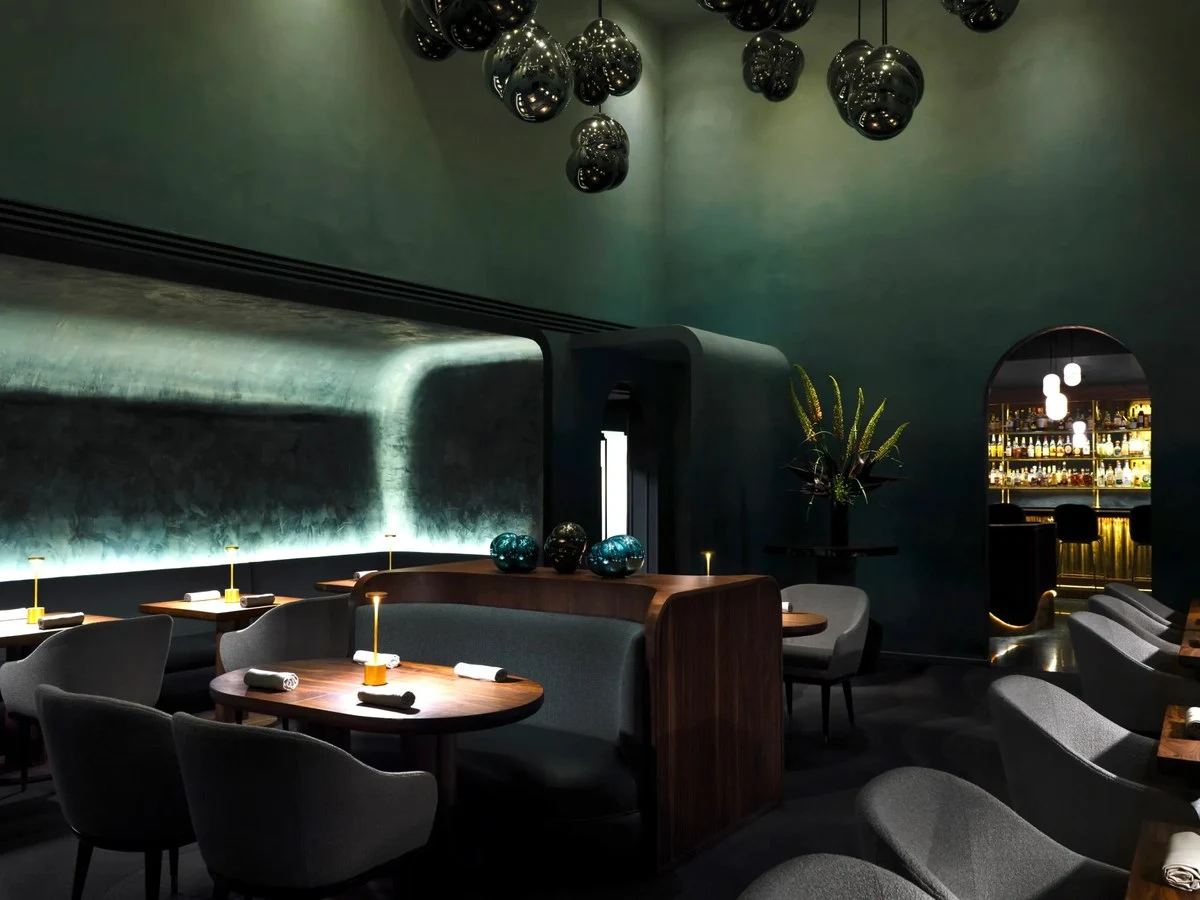 Providence's elegant dining room, with its deep teal walls and modern lighting, offers a sophisticated ambiance.