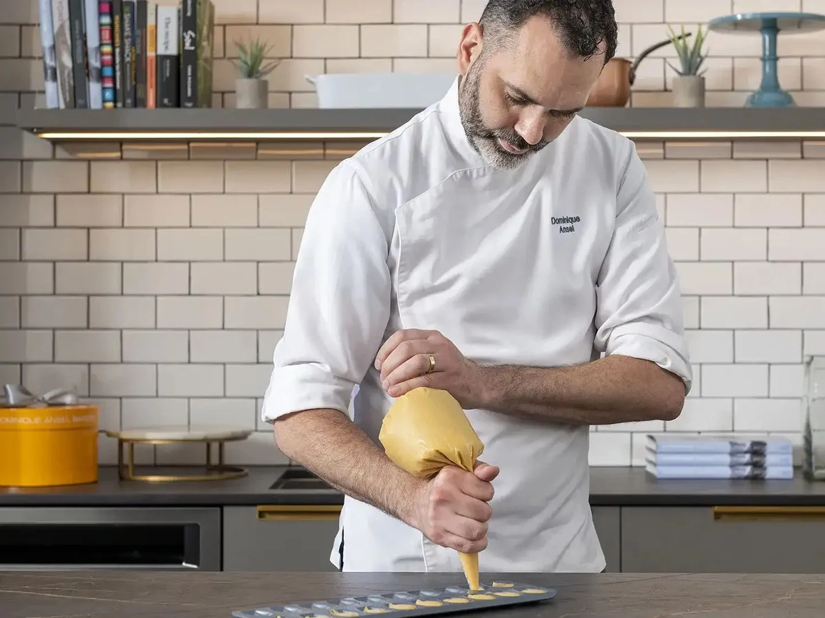 Dominique Ansel pipes choux by hand, demonstrating the craft at Dominique Ansel Kitchen.