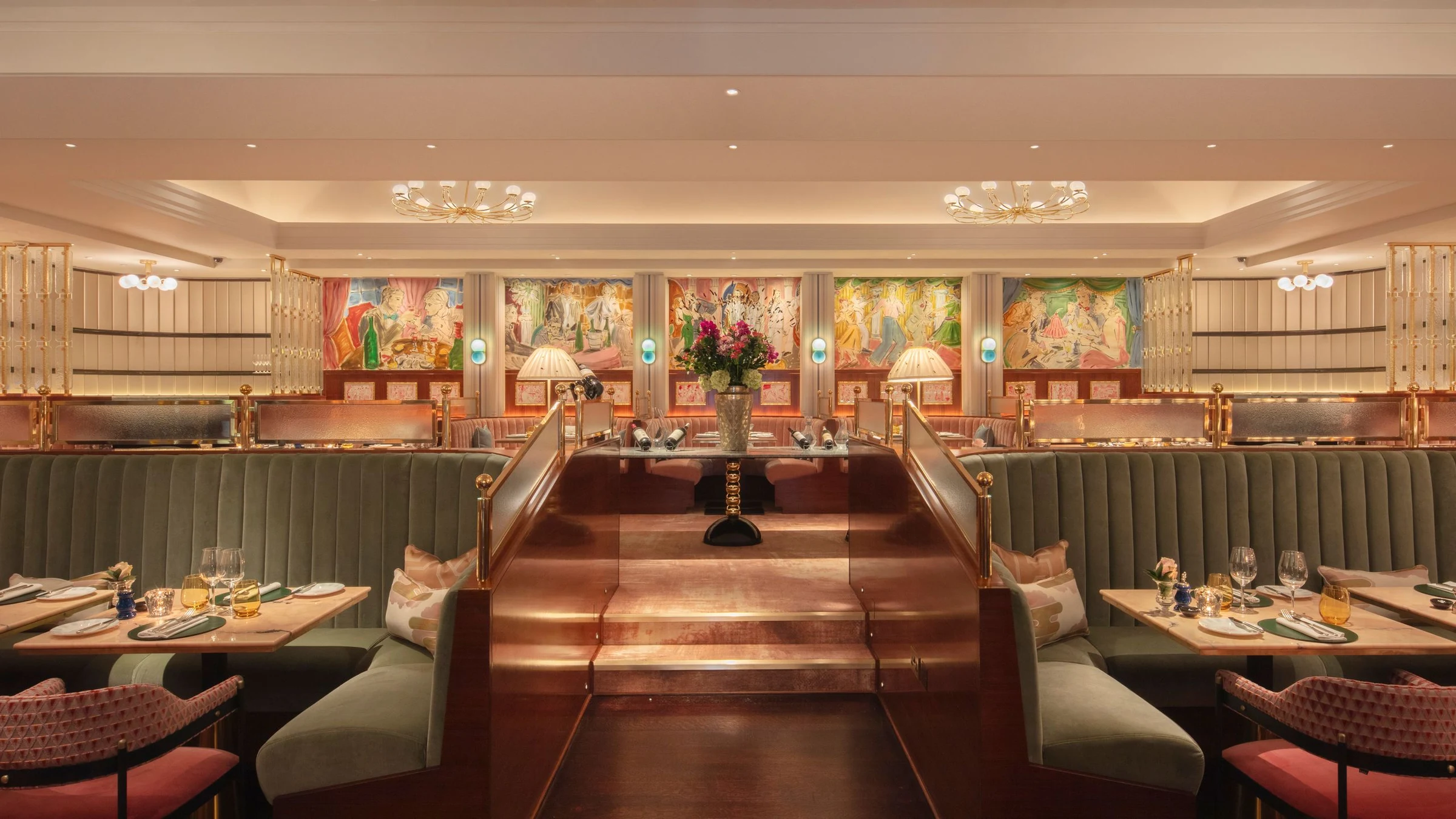 An upscale restaurant dining room with green banquette seating on both sides, wooden tables, classical paintings on burgundy walls, and ornate ceiling fixtures.