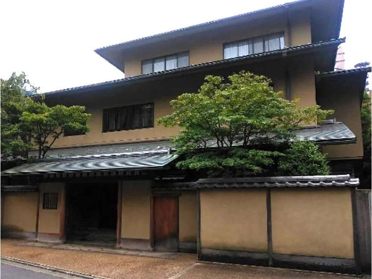 Traditional Japanese building with a tiled roof and surrounding wall.