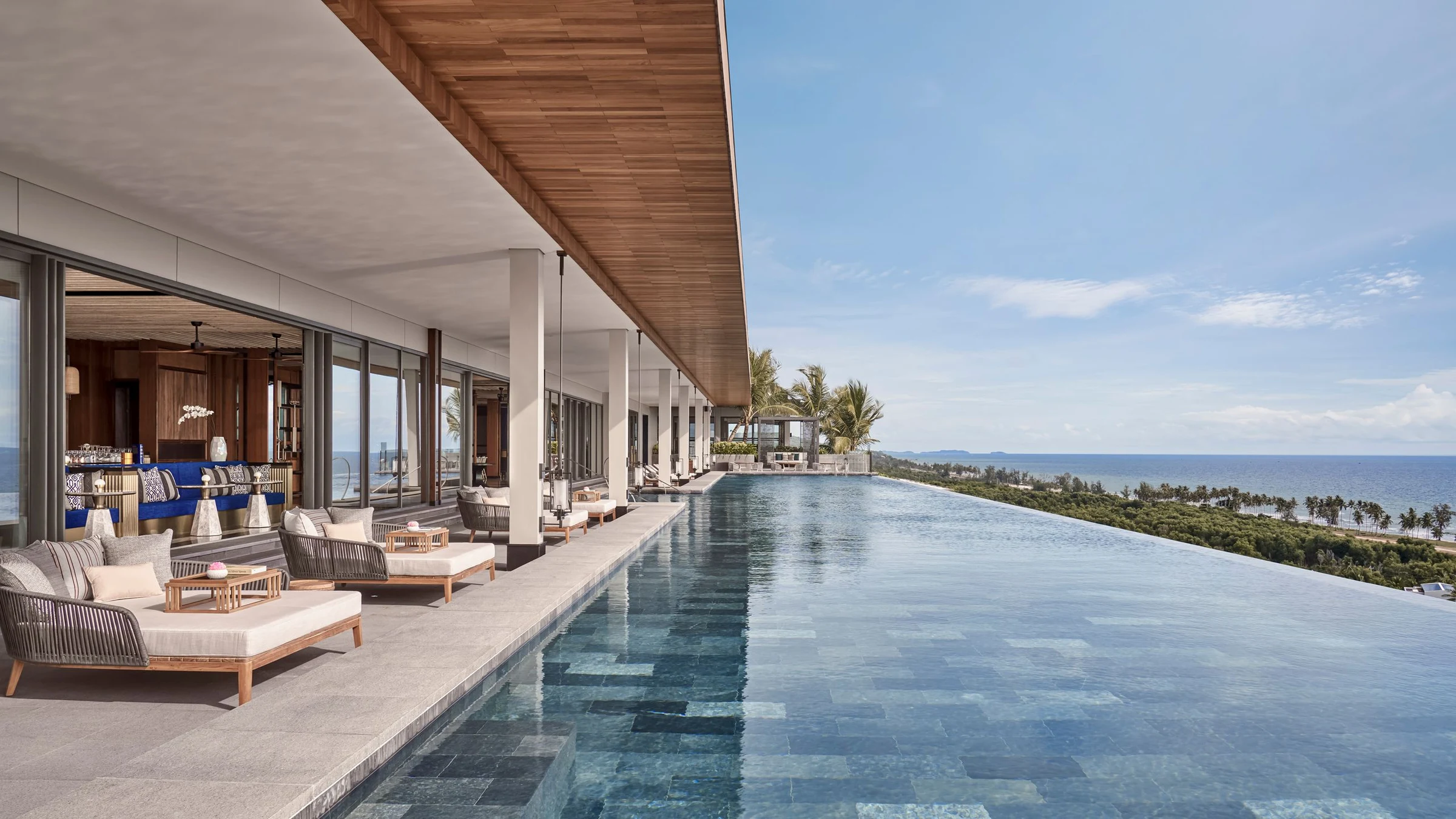 Luxury infinity pool with ocean views, sun loungers, and covered terrace at a high-end resort